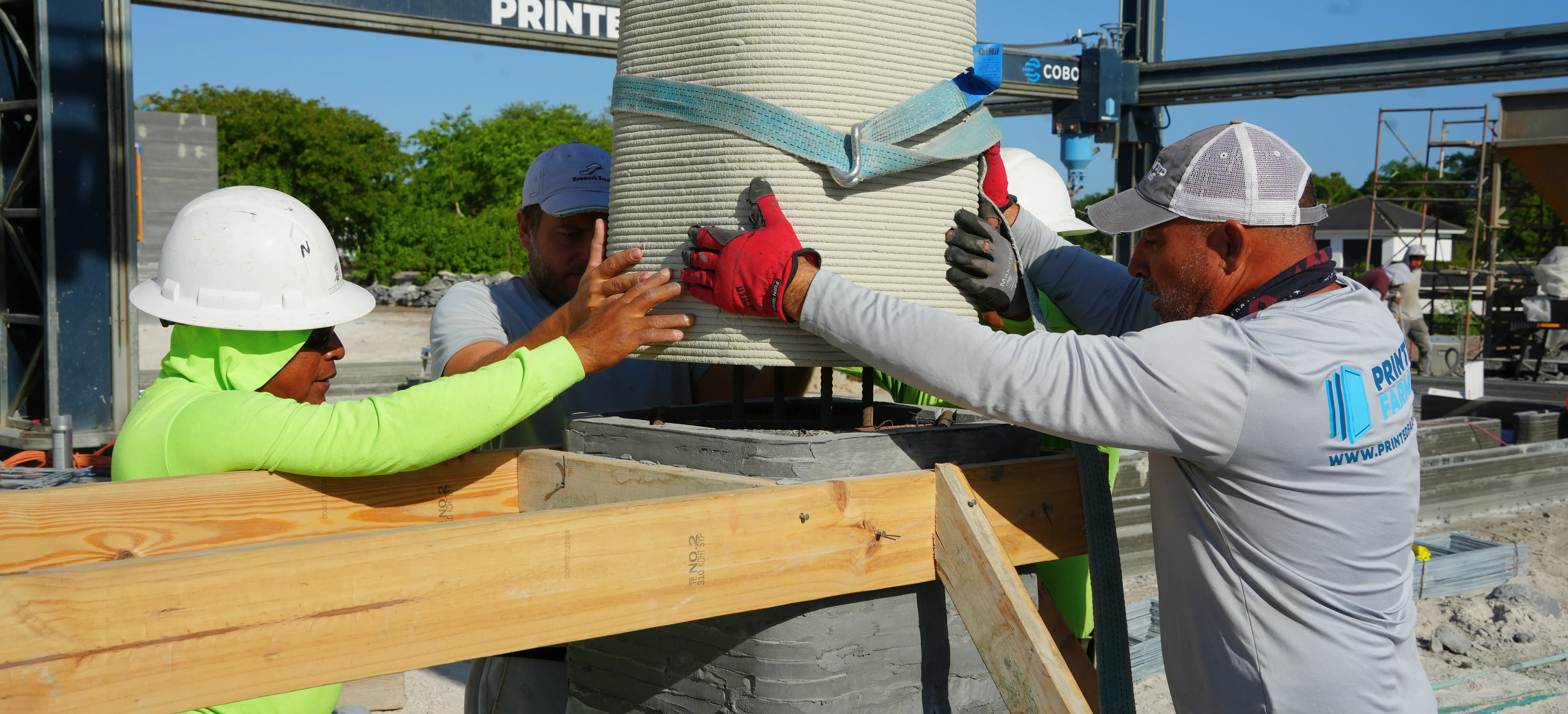 Worker guiding a concrete column into place at Wellington Farms