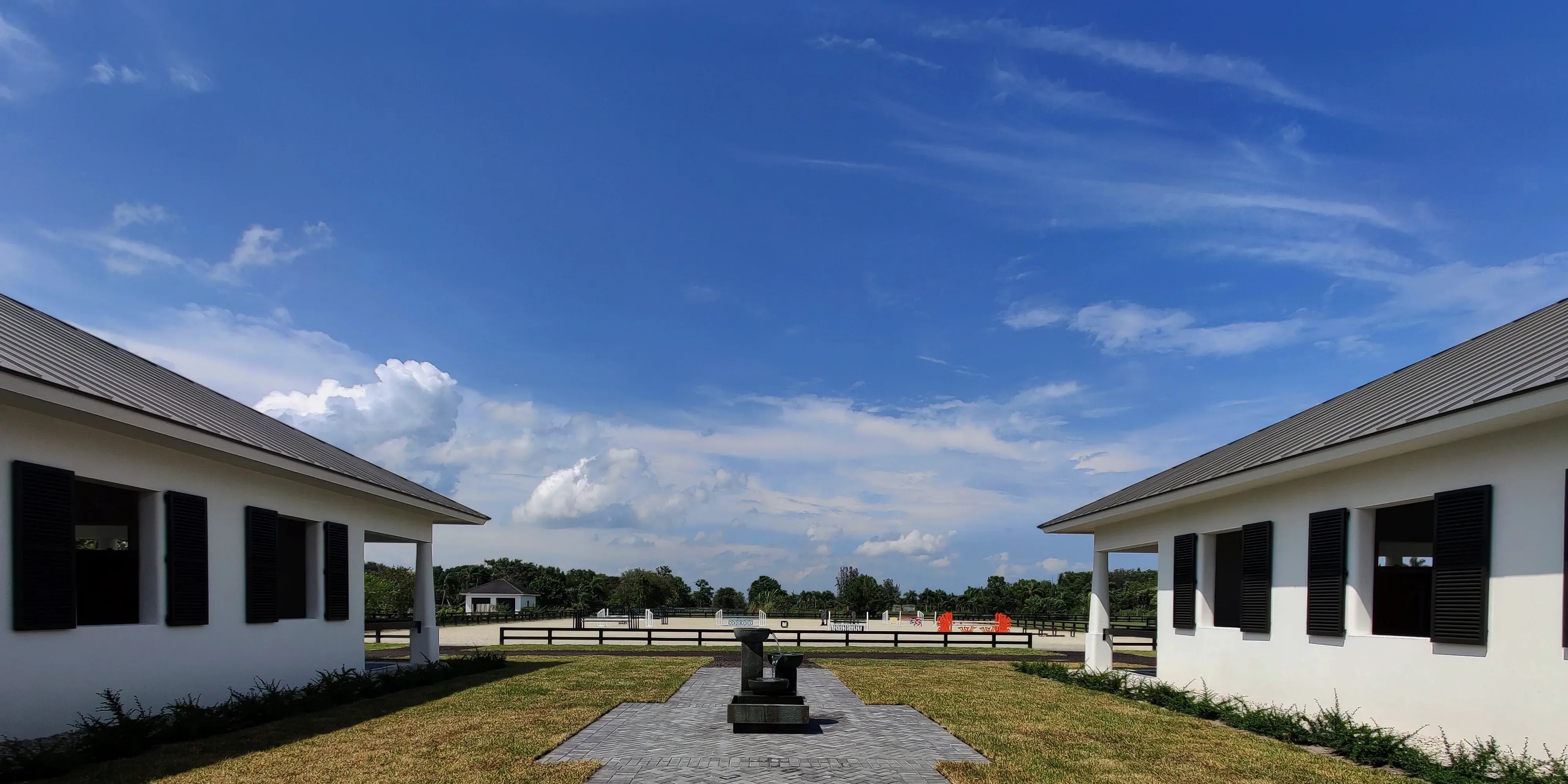 View from Wellington Farms showing concrete column-lined buildings and horse training field