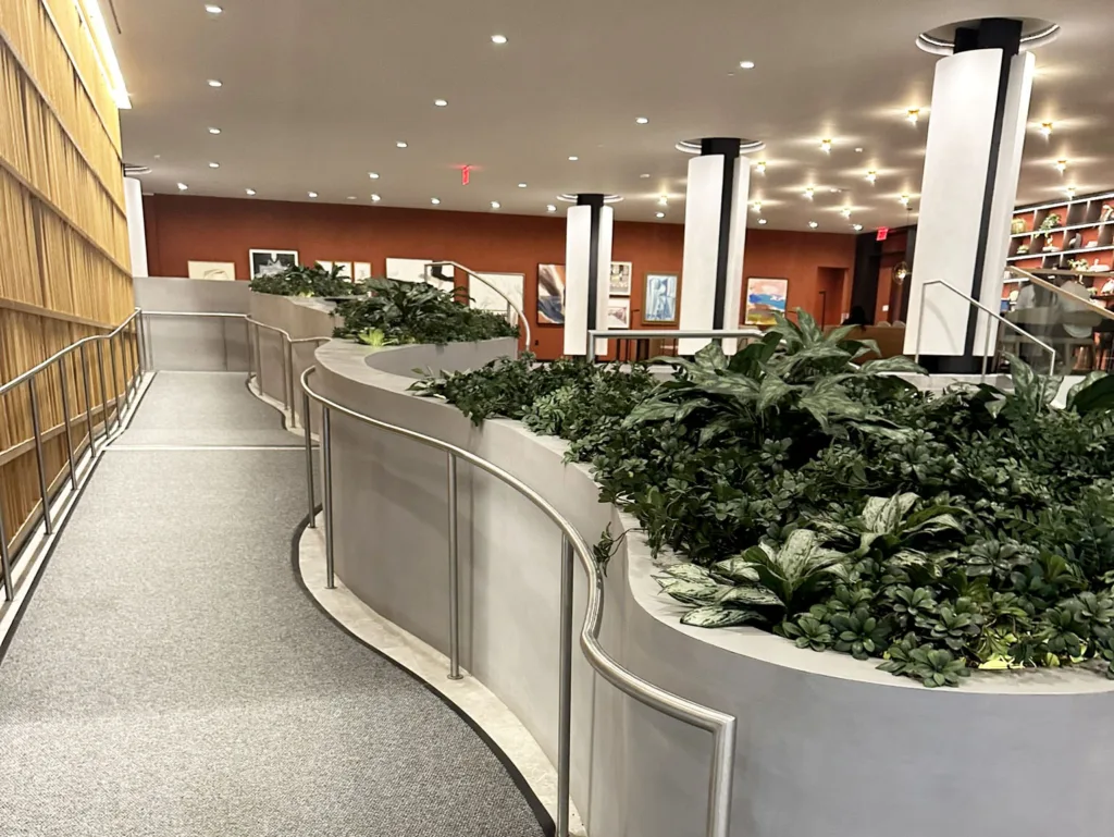 View from the base of the ADA ramp showing the full 3D printed concrete seating and planter feature in the main lobby of SoMa Residences at 25 Water in New York City.