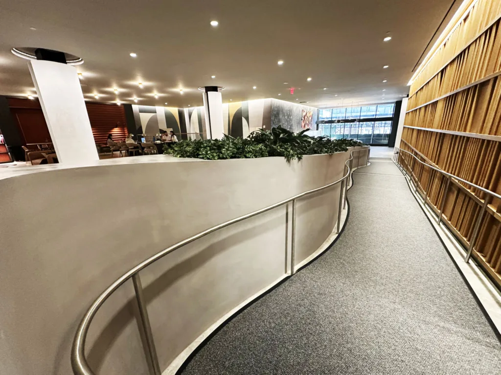 View from the ADA ramp showing the full 3D printed concrete seating and planter feature in the main lobby of SoMa Residences at 25 Water in New York City.