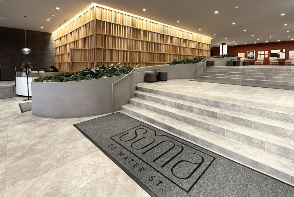 Side view of the 3D printed concrete planter and seating feature in the main lobby of SoMa Residences at 25 Water, seen from the base of the stairs.