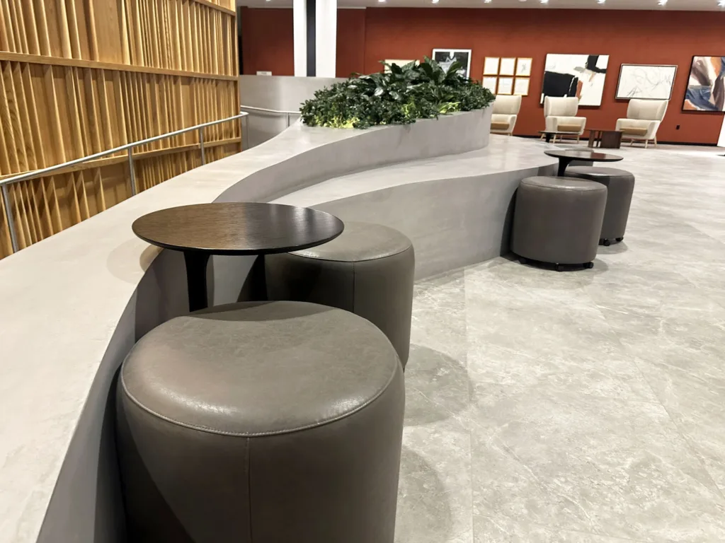 Another seating section of the 3D printed concrete feature in the main lobby of SoMa Residences at 25 Water, showing the smooth curved design and integrated planter.