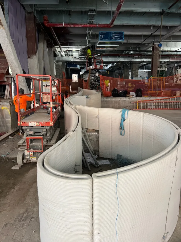 3D printed concrete lobby bench sections assembled together before smooth finish application at 25 Water Street New York