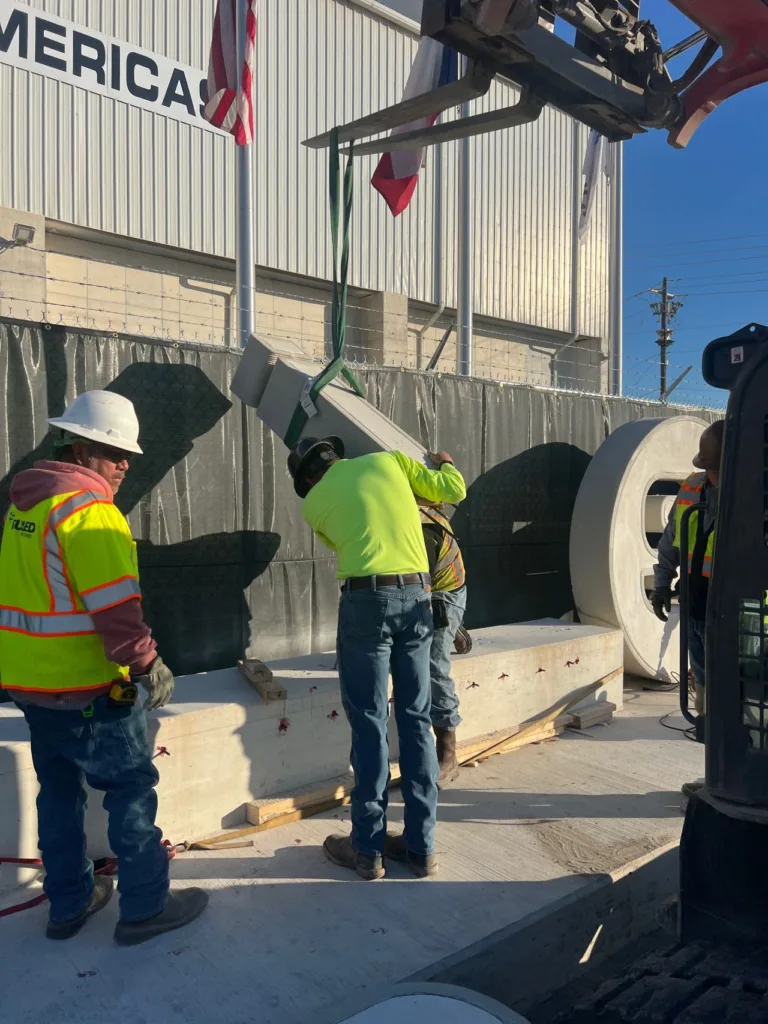 Workers installing a custom 3D printed concrete monument sign segment fabricated by Printera for CIMSA Americas